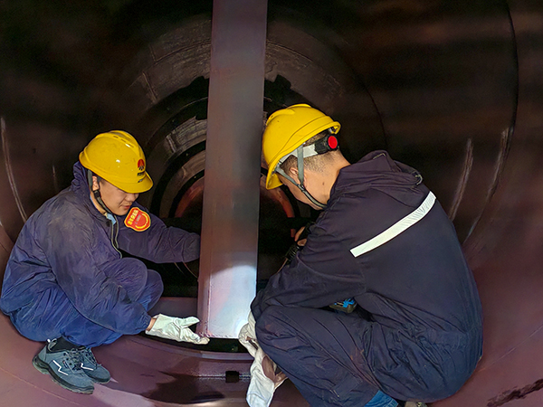 技术员王伟正在给青工岳维哲讲解除氧器内部结构.jpg